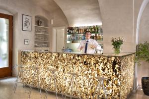 a man standing behind a bar in a room at Three Storks in Prague