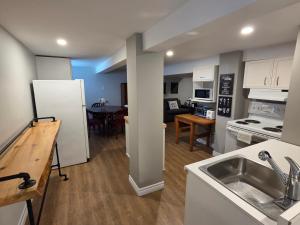 a kitchen with a sink and a refrigerator and a table at Guest house in Shawinigan