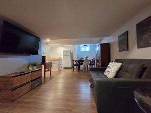 a living room with a couch and a flat screen tv at Guest house in Shawinigan