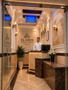 a man sitting at a reception desk in a hotel lobby at El Amin Hotel & Suites - Downtown Cairo in Cairo