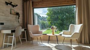 a room with a table and chairs and a large window at Pura Vida Mountain Glamping-tiny houses and tents in Moieciu de Jos