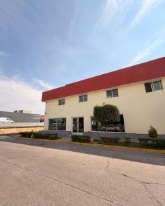 a large white building with a red roof at Hotel NV in Guadalajara