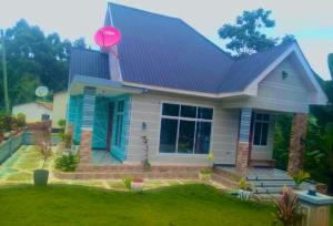 a small house with a blue roof at Usambara Homes in Manga