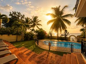 a resort with a pool and palm trees and the ocean at Ocean view in Pointe aux Biches