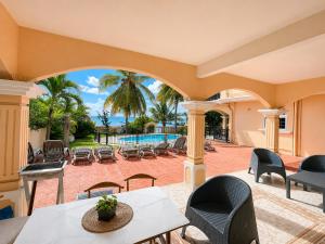 an outdoor patio with tables and chairs and a pool at Ocean view in Pointe aux Biches