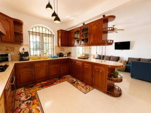 a kitchen with wooden cabinets and a living room at Ocean view in Pointe aux Biches