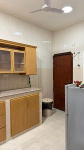 a kitchen with wooden cabinets and a stainless steel refrigerator at شقه مستقله بالقرب من مطار صلاله in Salalah +9 photos
