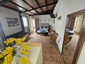 a room with a bed and a table with yellow flowers at Singular Goldsmith in Mexico City