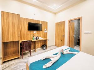 a bedroom with a bed with a television and a desk at New sheth bnb golden temple in Amritsar