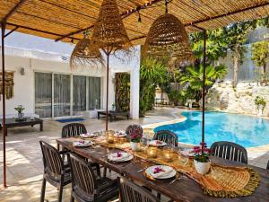 a dining table and chairs in a patio with a pool at Fantastic 6B Villa in Sidi Daoud