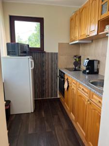 a kitchen with wooden cabinets and a white refrigerator at Сонита in Yamna