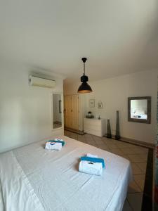 a bedroom with a white bed with towels on it at Moradia Almorávia in Olhos de Água +49 photos