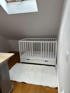 a crib in the corner of a room with a window at Kościelnik Park Apartament in Lubań