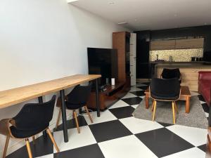 a living room with a checkered floor and a table and chairs at Kościelnik Park Apartament in Lubań