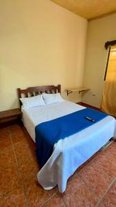 a bedroom with a large bed with a blue blanket at Accommodation #7 in Copán Ruinas