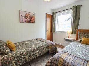 a hotel room with two beds and a window at Steam Cottage in Aviemore