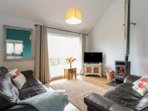 a living room with a couch and a fireplace at Poppies Cottage in Craignure