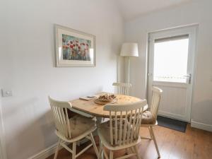 a dining room with a wooden table and chairs at Poppies Cottage in Craignure