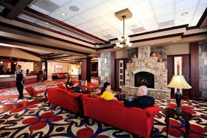 a lobby with people sitting on couches in front of a fireplace at Cherokee Casino West Siloam Springs Resort in West Siloam Springs