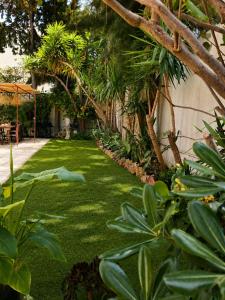 a garden with green grass and trees next to a building at Fantastic 6B Villa in Sidi Daoud