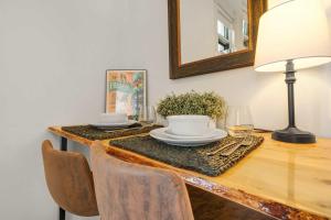 a table with a lamp and a plate of food on it at Downtown Palace Hotel Suite - Steps to Adventure in Salida