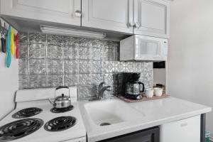 a white kitchen with a sink and a stove at Downtown Palace Hotel Suite - Steps to Adventure in Salida
