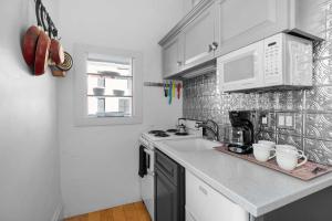 a kitchen with a sink and a stove and a microwave at Downtown Palace Hotel Suite - Steps to Adventure in Salida