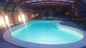 a large swimming pool in a building with a ceiling at A Loffre Zen in Loffre