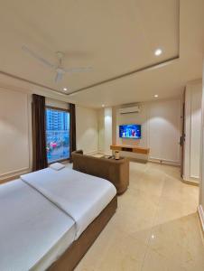 a large bedroom with a large bed and a flat screen tv at Hotel River Front in Kota