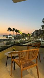 a table and a chair and a table and a view of a city at Marina Premium Beach Hotel & Apartments in Vlorë