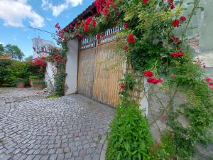 a wooden gate with red flowers on a fence at Pensiunea Keisd in Saschiz