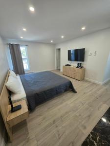 a bedroom with a large bed and a flat screen tv at Le 2020 Charlevoix in La Malbaie