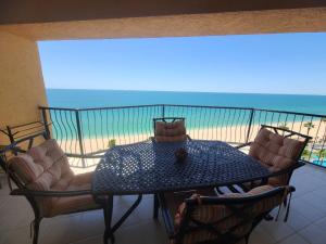 a table and chairs on a balcony with the beach at Sonoran Sea 2 Bedroom 2 Bath 7th Floor in Puerto Peñasco