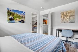 a white bedroom with a bed and a desk and a chair at 4BR Downtown Basecamp - Walk to Everything in Salida