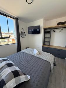 a bedroom with a bed and a tv on the wall at Dpto familiar moderno 2do piso - 2 Hab - 3 camas - wifi - lavadora in Tacna