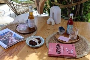 a table with two bottles of wine and a plate of cake at Origines Be Holistic in Brengues +12 photos