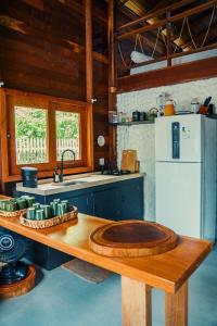 a kitchen with a wooden table and a white refrigerator at Vilarejo in Belém