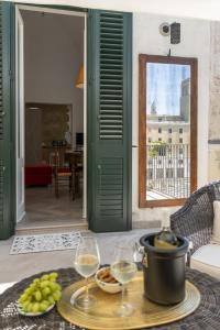 a table with wine glasses and a tray of food at Biccari 6 Terrace Apartament in Lecce