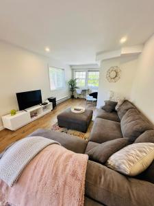 a living room with a large couch and a flat screen tv at The Wineries are Calling! in Penticton