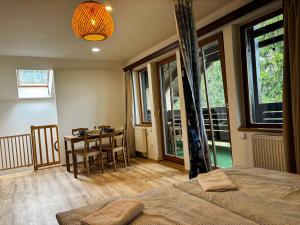 a bedroom with a bed and a table with chairs at Apartmány Kořenný in Korěnný