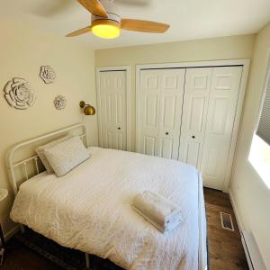 a bedroom with a bed with a ceiling fan at The Wineries are Calling! in Penticton