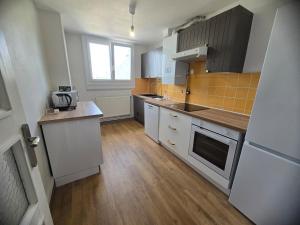 a kitchen with white appliances and a wooden floor at Atria SILS in Caen