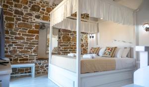 a bedroom with a bed and a brick wall at Rodakas Rooms-Glikeria in LivadhokhÃ³rion +14 photos