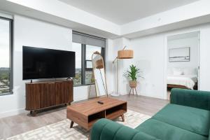 a living room with a couch and a tv at Central Upscale 2BR Condo wGym Office & Parking in Cambridge