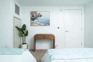 a white bedroom with two beds and a table at Central Upscale 2BR Condo wGym Office & Parking in Cambridge +41 photos