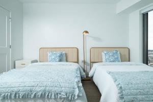 a bedroom with two beds with blue and white sheets at Central Upscale 2BR Condo wGym Office & Parking in Cambridge