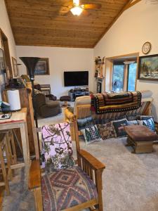 a living room with couches and a tv at Hideaway from the Twin Cities in Houlton