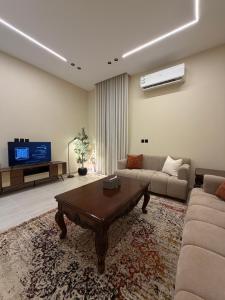 a living room with a couch and a coffee table at SORANO Apartments in Hail