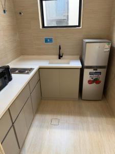 a small kitchen with a refrigerator and a sink at SORANO Apartments in Hail