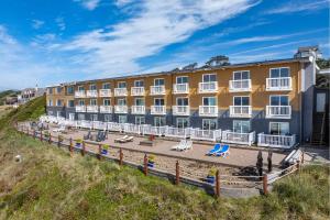 a hotel on the beach with beach chairs and a building at Sailor Jack Oceanfront Motel in Lincoln City